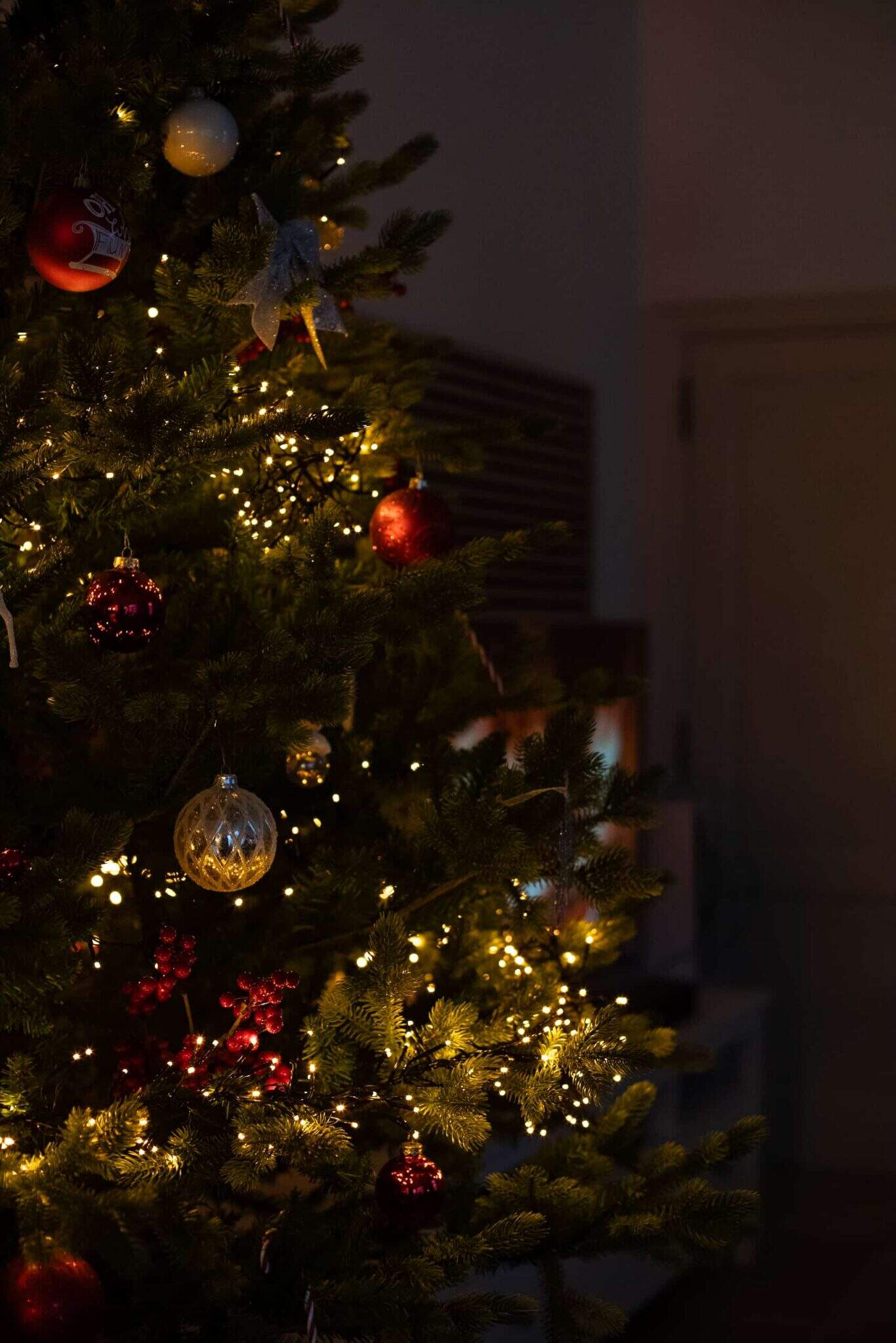 Kerstboom versierd met lichtjes en traditionele kerstballen voor feestelijke sfeer.